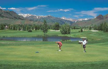 A couple golfing in Sun Valley, Idaho. golf, green, putt, mountains, idaho, scenic, course, cart, resort, vacation, holiday, destination, travel, tourism, recreation, exercise, sport, diversion, fun, romance