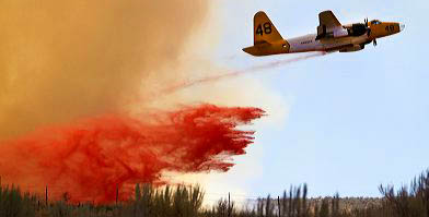 P2 fire bomber aircraft dropping phosphate fire retardant on a wildfire near Boise, Idaho, USA.