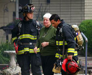 Firefighters assist a resident during a house fire in Boise. FILE PHOTO